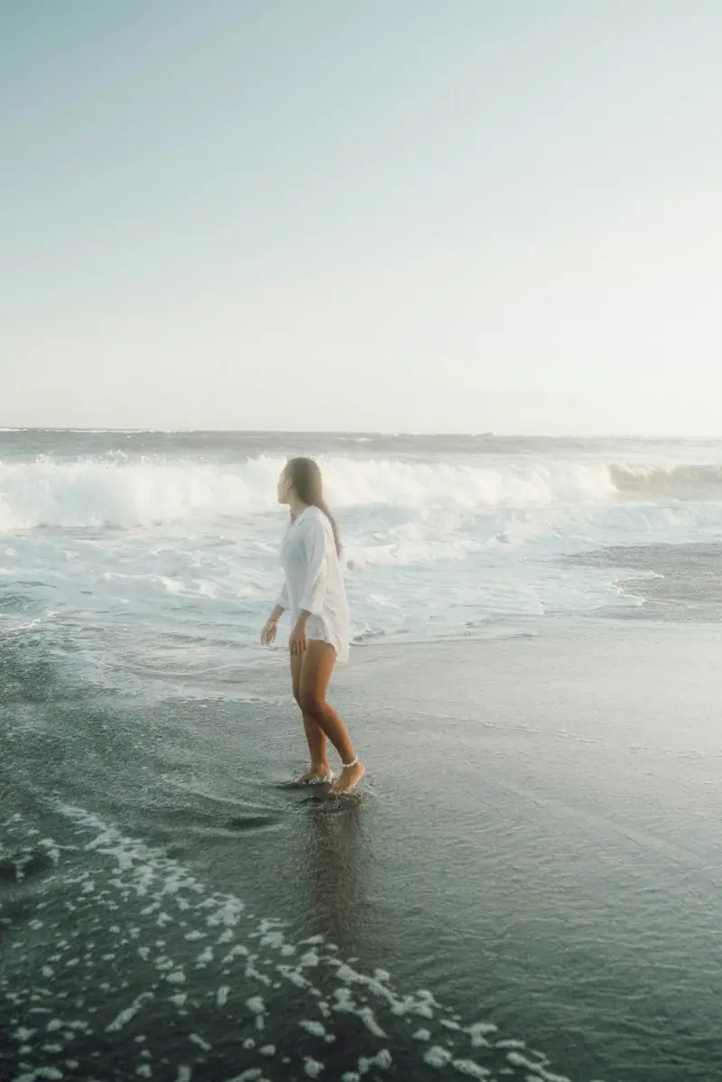 A person walking along the surf at Canggu Beach