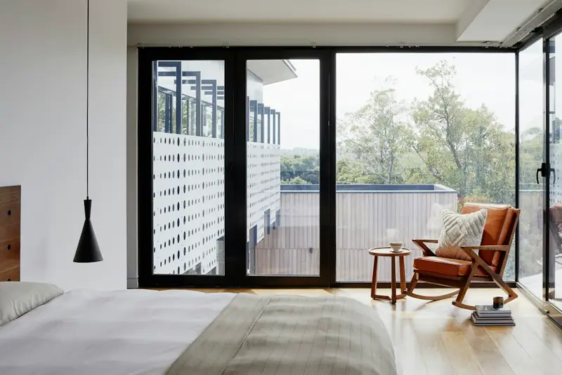 Illustrative light-filled sitting area with an armchair and large windows