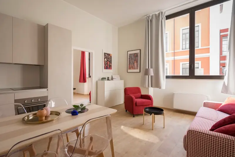 Illustrative apartment living and dining area with a red armchair