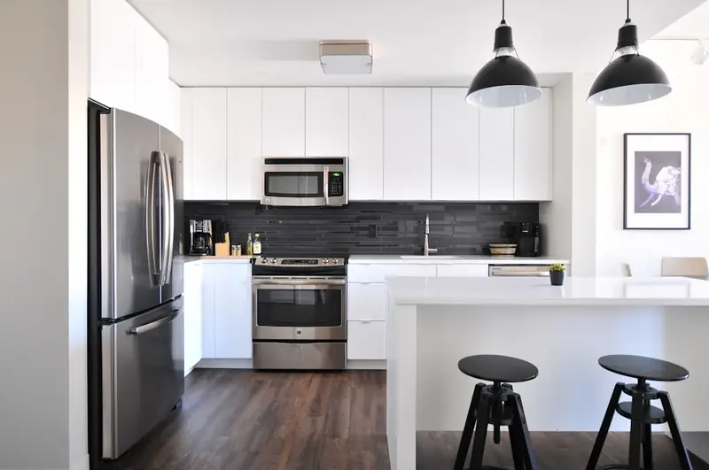 Illustrative white kitchen with dark worktops and breakfast stools