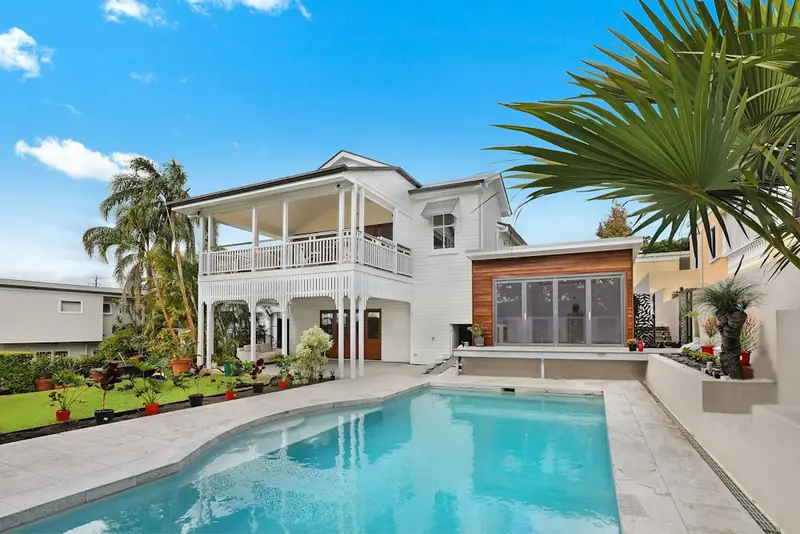 Illustrative house exterior with a swimming pool and palm trees
